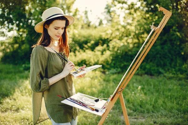 Elegante e bella ragazza pittura in un campo — Foto Stock