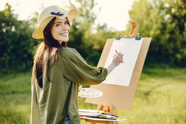 Elegante e bella ragazza pittura in un campo — Foto Stock