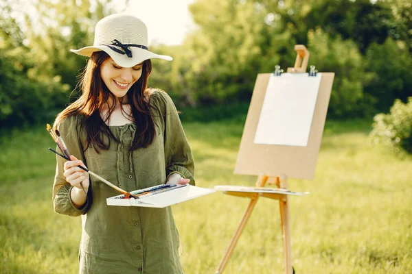 Elegante e bella ragazza pittura in un campo — Foto Stock