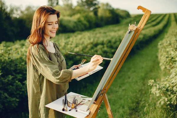 Elegante e bella ragazza pittura in un campo — Foto Stock