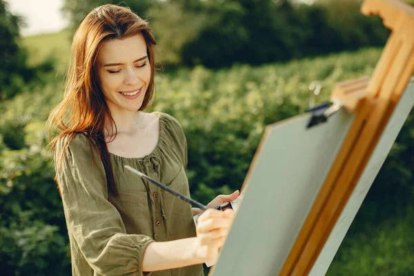 Elegant and beautiful girl painting in a field — Stock Photo, Image