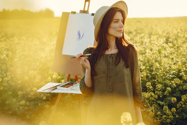 Elegante e bella ragazza pittura in un campo — Foto Stock