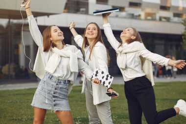 Öğrenci kampüsünde telefonlu genç öğrenciler.