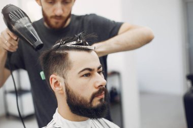 Berber dükkanında oturan şık bir adam.