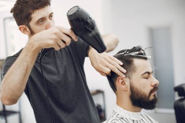 Berber dükkanında oturan şık bir adam.