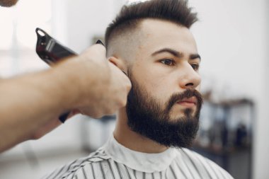 Berber dükkanında oturan şık bir adam.