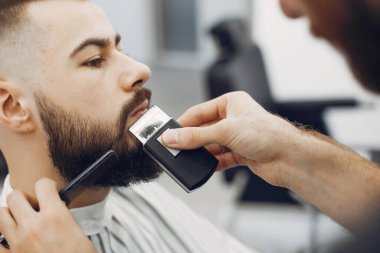 Berber dükkanında oturan şık bir adam.