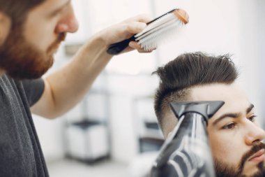 Berber dükkanında oturan şık bir adam.