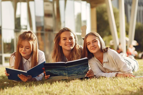 Trzech studentów leżących na trawie z książkami — Zdjęcie stockowe