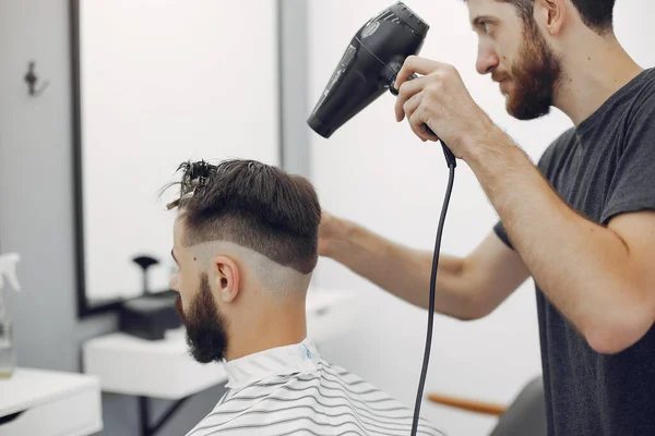 Stilvoller Mann sitzt in einem Friseurladen — Stockfoto