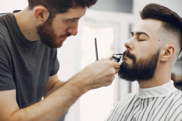 Stilvoller Mann sitzt in einem Friseurladen — Stockfoto