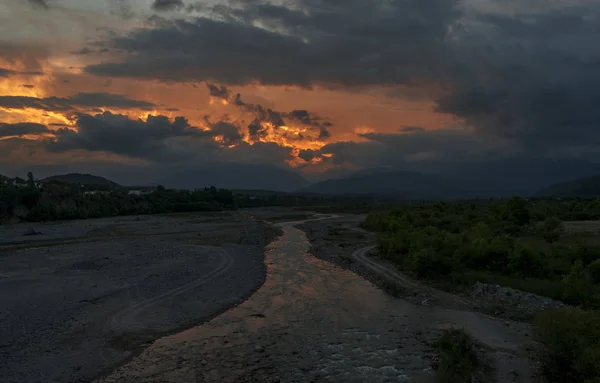 Pôr do sol sobre um rio de montanha — Fotografia de Stock