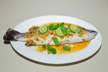 Beyaz tabakta limon soslu balık buğulama