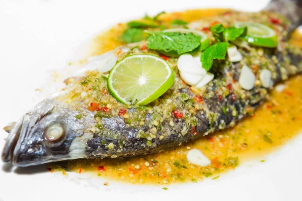 Beyaz tabakta limon soslu balık buğulama