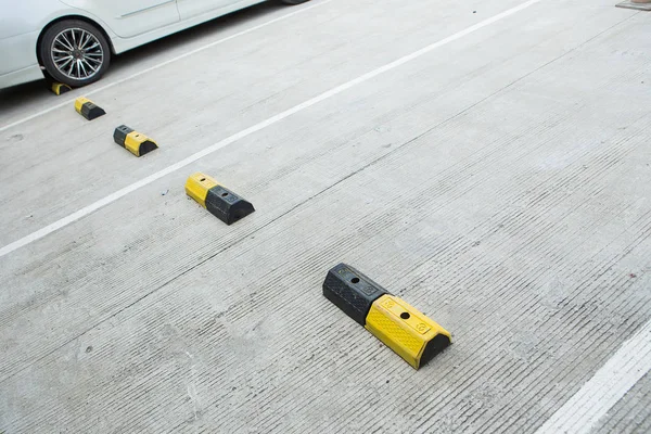 Concrete for cars brake with yellow traffic lines in car parking