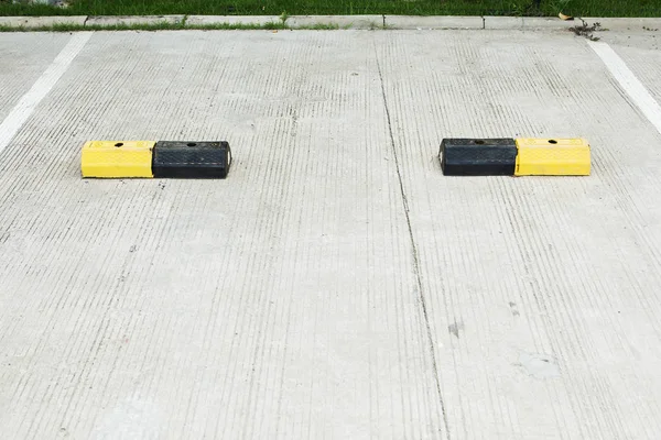 Concrete for cars brake with yellow traffic lines in car parking — Stock Photo, Image