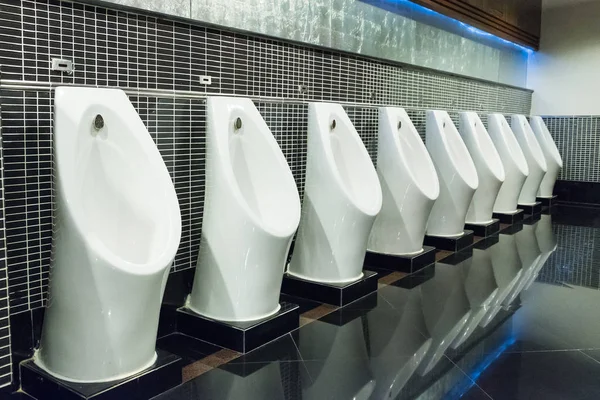 Biały pisuar w publicznej toalecie mężczyzn z czarnej ścianie płytki — Zdjęcie stockowe