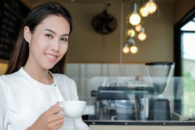 Asyalı kadın zevk kafede kahve ile.