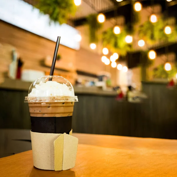 Bulanık kahve ca ile ahşap masa üzerinde paket servisi olan restoran Kupası'nda buzlu kahve — Stok fotoğraf