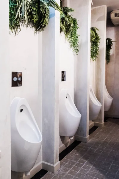 Urinario blanco en hombres baño público con azulejo de pared negro —  Fotos de Stock