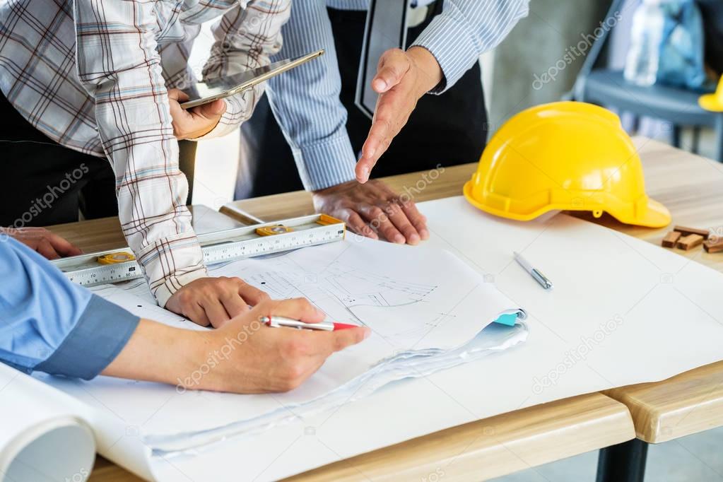 A group of engineers are looking at a blueprint for construction