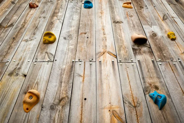 Mão e pés em uma parede de escalada ao ar livre de madeira em um perto — Fotografia de Stock