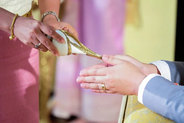 Pouring water from the conch shell into the bride's hands at a T — Stock Photo, Image