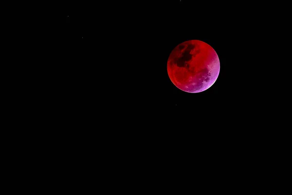 Concepto de luna de sangre de una luna llena roja contra un cielo negro — Foto de Stock