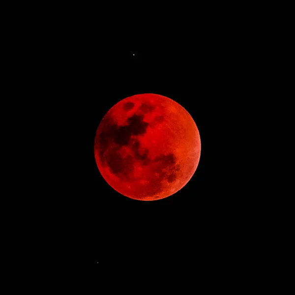 Concepto de luna de sangre de una luna llena roja contra un cielo negro — Foto de Stock