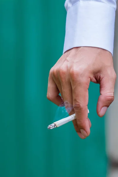 Man hands with cigarette on green background. — Stock Photo, Image