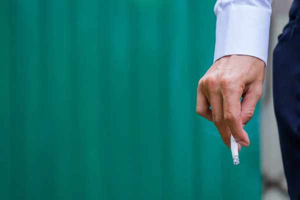 Homme mains avec cigarette sur fond vert . — Photo