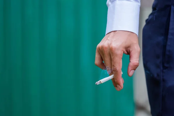 Homme mains avec cigarette sur fond vert . — Photo