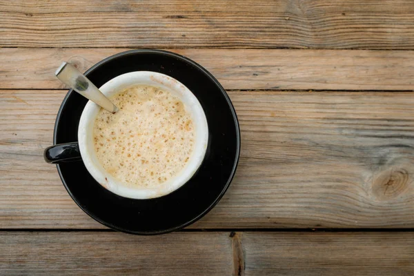 Rano Kawa i filiżankę kawy na drewnianym stole. — Zdjęcie stockowe