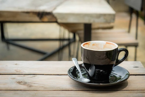 Poranna kawa napój jest prawie nie było, z drewnianym stołem — Zdjęcie stockowe