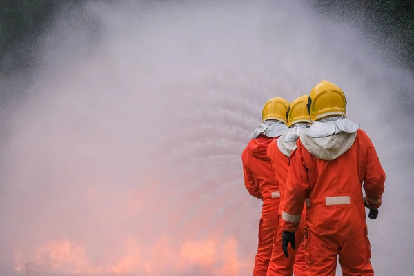 Firefighter are using water in fire fighting operation — Stock Photo, Image
