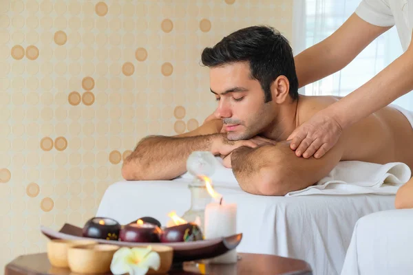 Hermoso hombre durante el masaje con aceite esencial en la habitación spa Imagen de stock