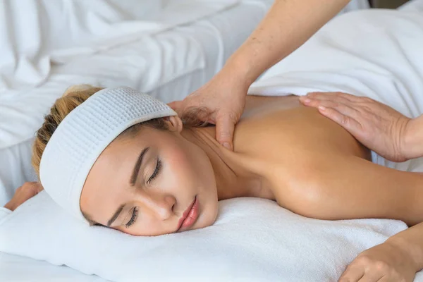 Bela mulher durante a massagem com óleo essencial no spa quarto — Fotografia de Stock