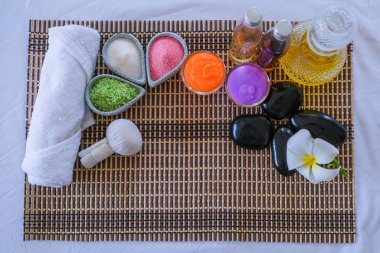 Spa seti ve yatak masajında aromatik masaj yağı. Aroma terapisi için Tayland seti ve yatakta çiçekle masaj, rahatlama ve sağlıklı bakım.