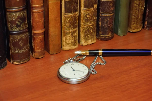 Libro antiguo, reloj y pluma — Foto de Stock