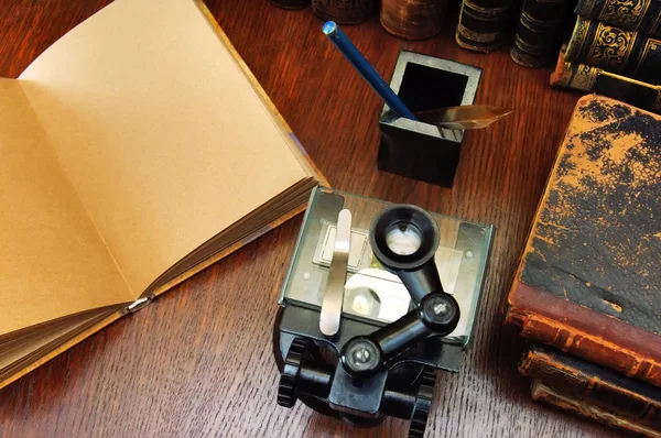 Microscópio e livros científicos antigos — Fotografia de Stock