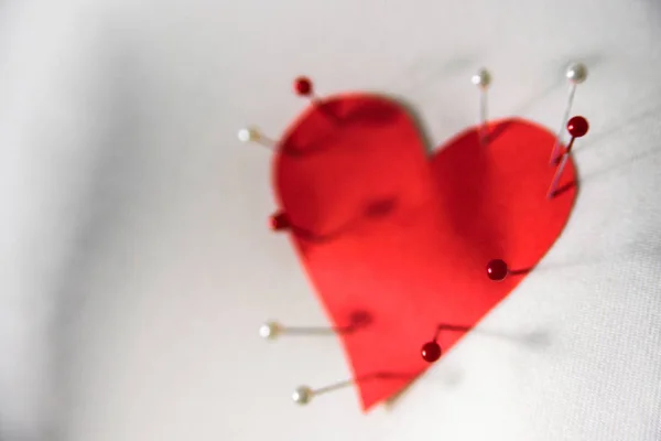 Pinned red paper heart to cloth