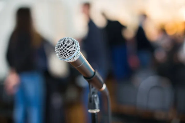 Microfone Vocal em foco contra audiência turva na conferência — Fotografia de Stock