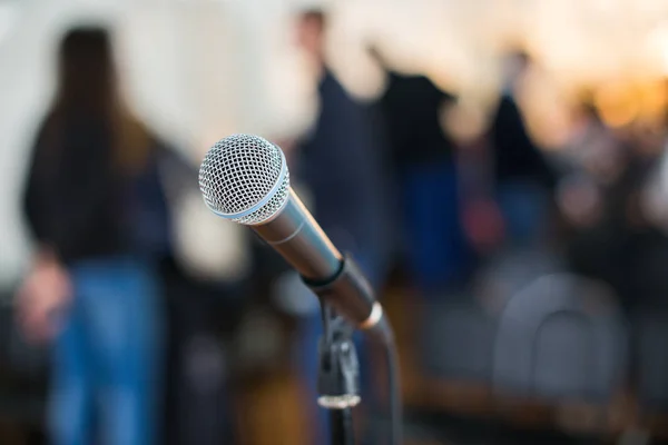 Micrófono vocal enfocado contra audiencia borrosa en la conferencia — Foto de Stock