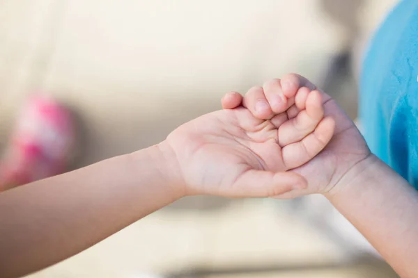 Syster håller baby hand — Stockfoto