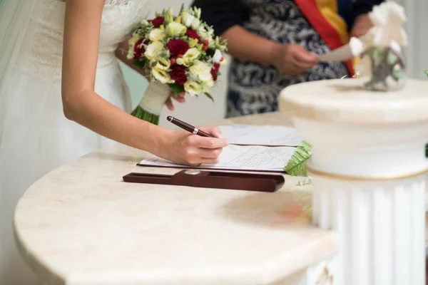 Noiva assina certidão de casamento com uma caneta — Fotografia de Stock