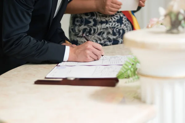 Groom assina certidão de casamento com uma caneta — Fotografia de Stock