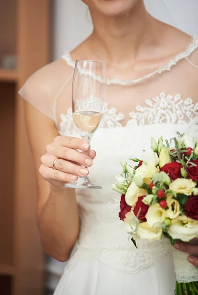 A noiva está segurando um buquê de casamento e uma taça de champanhe. — Fotografia de Stock