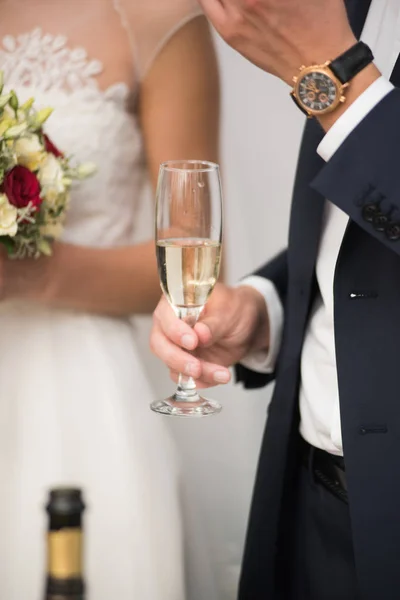 Groom está segurando uma taça de champanhe . — Fotografia de Stock