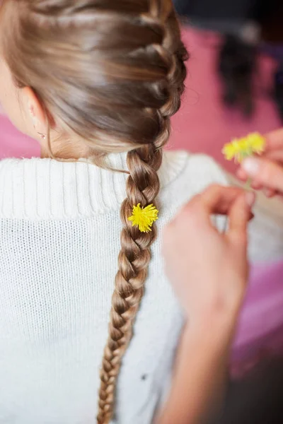 Jeune fille avec des fleurs dans ses cheveux de queue de cochon . — Photo