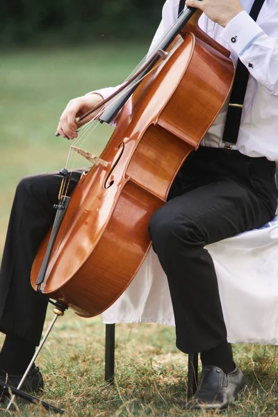 Junger Mann spielt draußen Cello. — Stockfoto